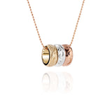 The picture shows a 14K rose, white, and yellow gold tricolor three ring pendant with hand engravings.