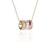 The picture shows a 14K rose, white, and yellow gold tricolor three ring pendant with hand engravings.