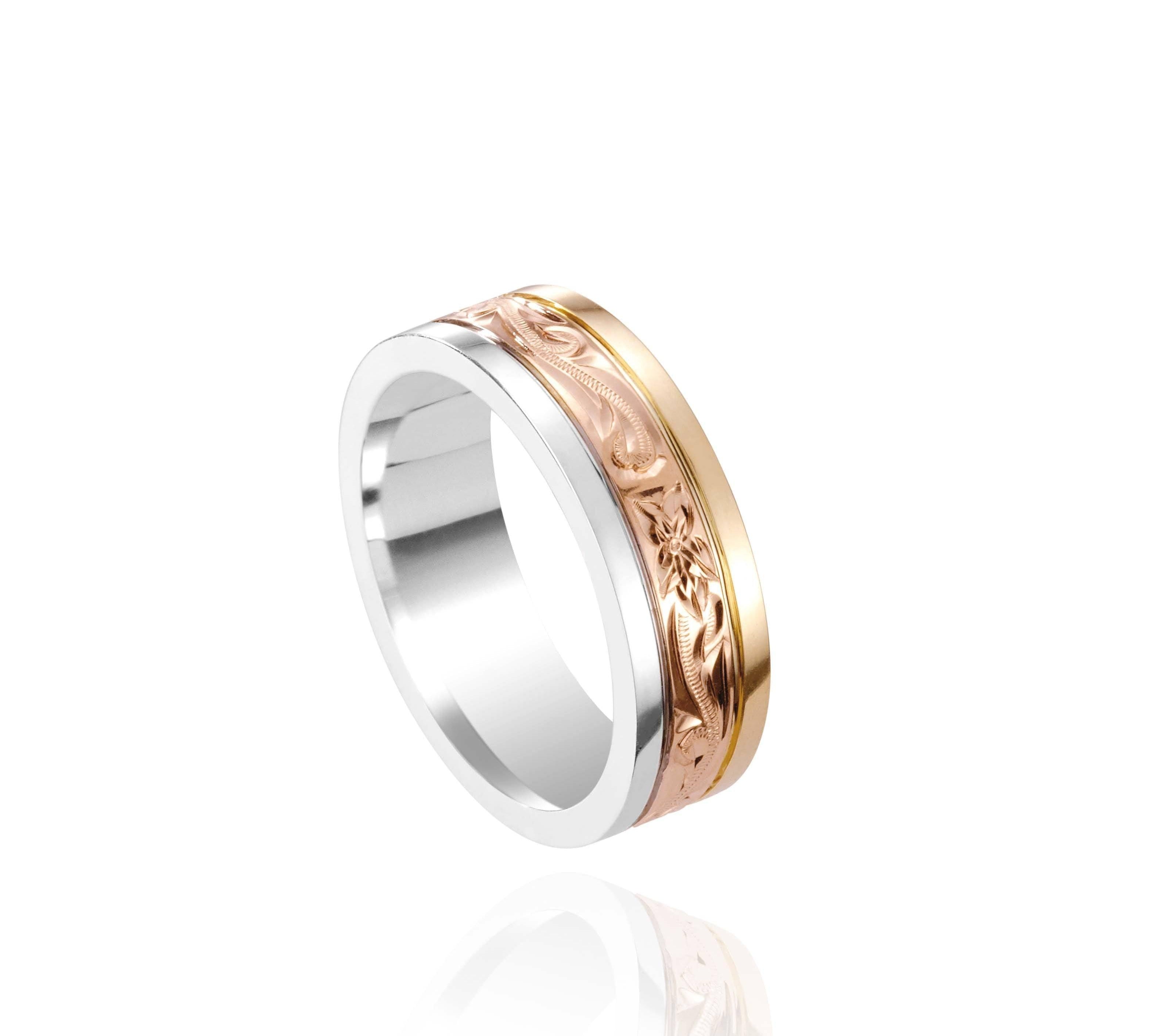 In this photo there is a yellow, rose, and white gold tricolor ring with flower and scroll hand engravings.