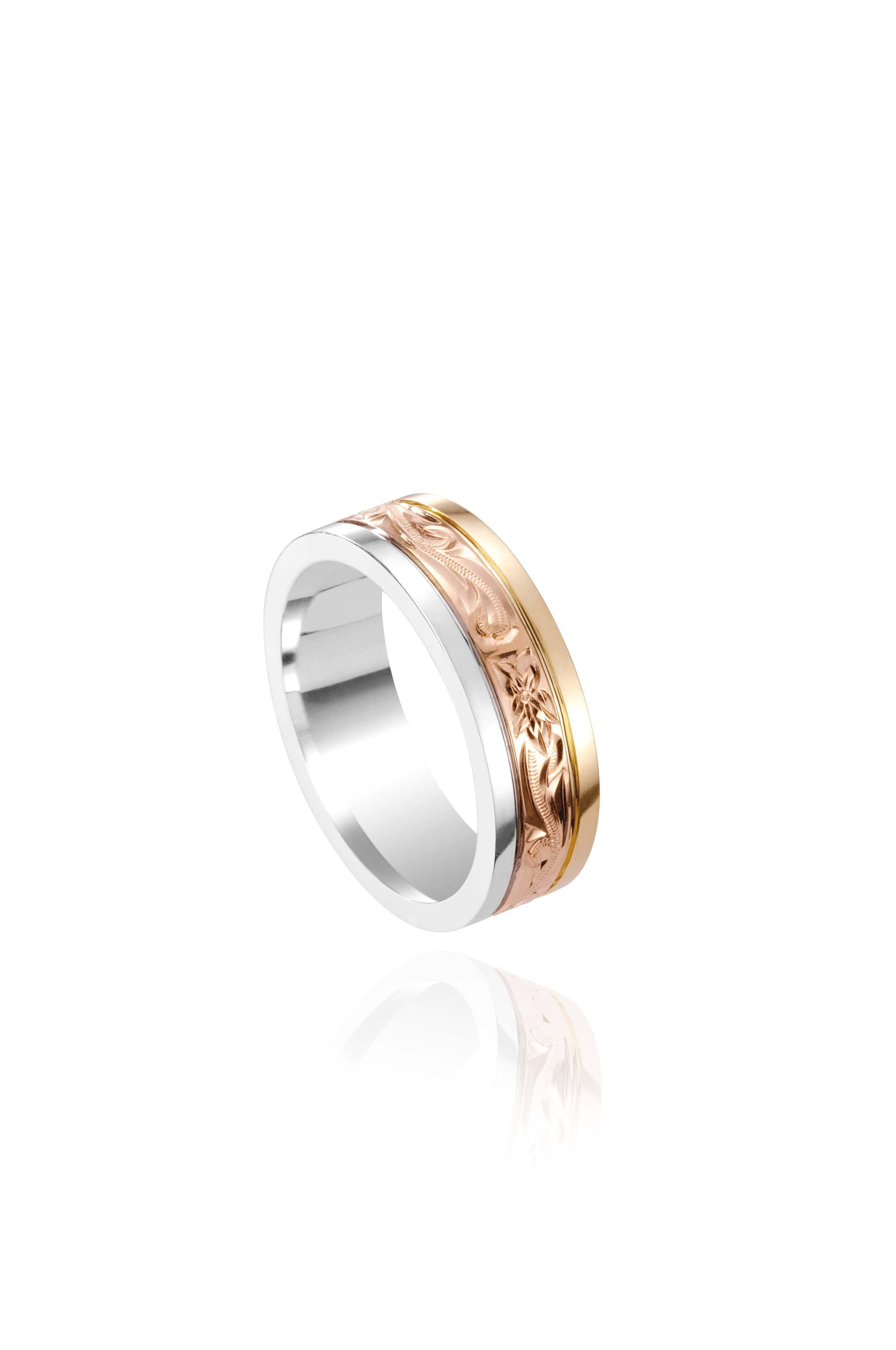 In this photo there is a yellow, rose, and white gold tricolor ring with flower and scroll hand engravings.
