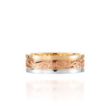 In this photo there is a yellow, rose, and white gold tricolor ring with flower and scroll hand engravings.