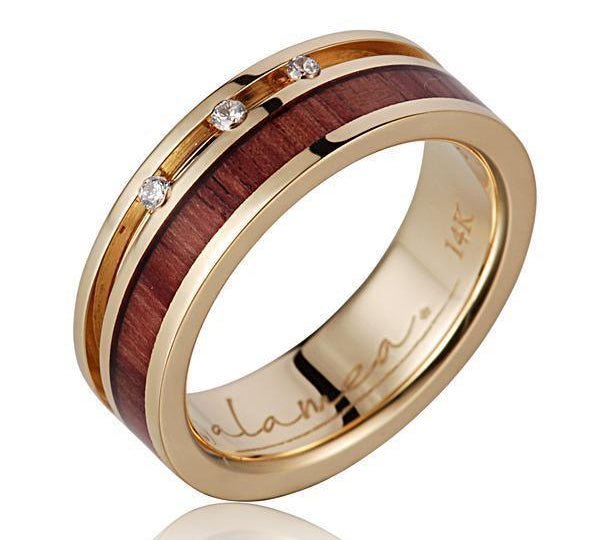 In this photo there is a 14K yellow gold and tulip poplar wood ring with three diamonds.