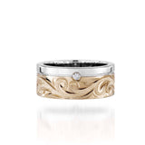The picture shows a 14K white and yellow gold two-tone 8 mm channel ring with a diamond and hand-engravings.
