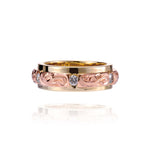 The picture shows a 14K yellow and rose gold two-tone infinity ring with diamonds and hand-engravings.