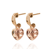 The picture shows a pair of 14K yellow and rose gold two-tone heart earrings with scroll engraving.