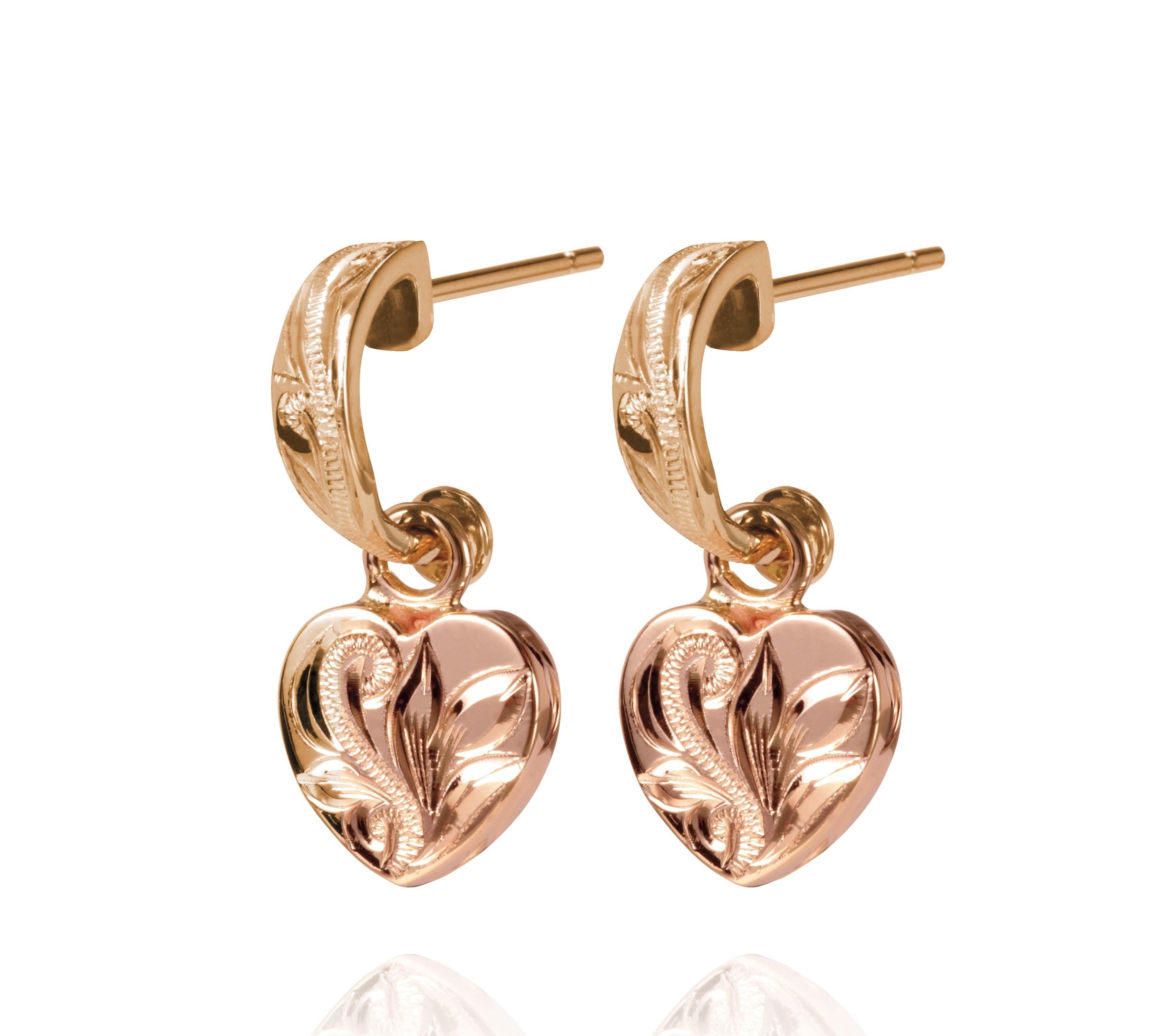 The picture shows a pair of 14K yellow and rose gold two-tone heart earrings with scroll engraving.