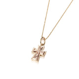 The picture shows a 14K yellow and rose gold two-tone cross pendant with hand engravings.