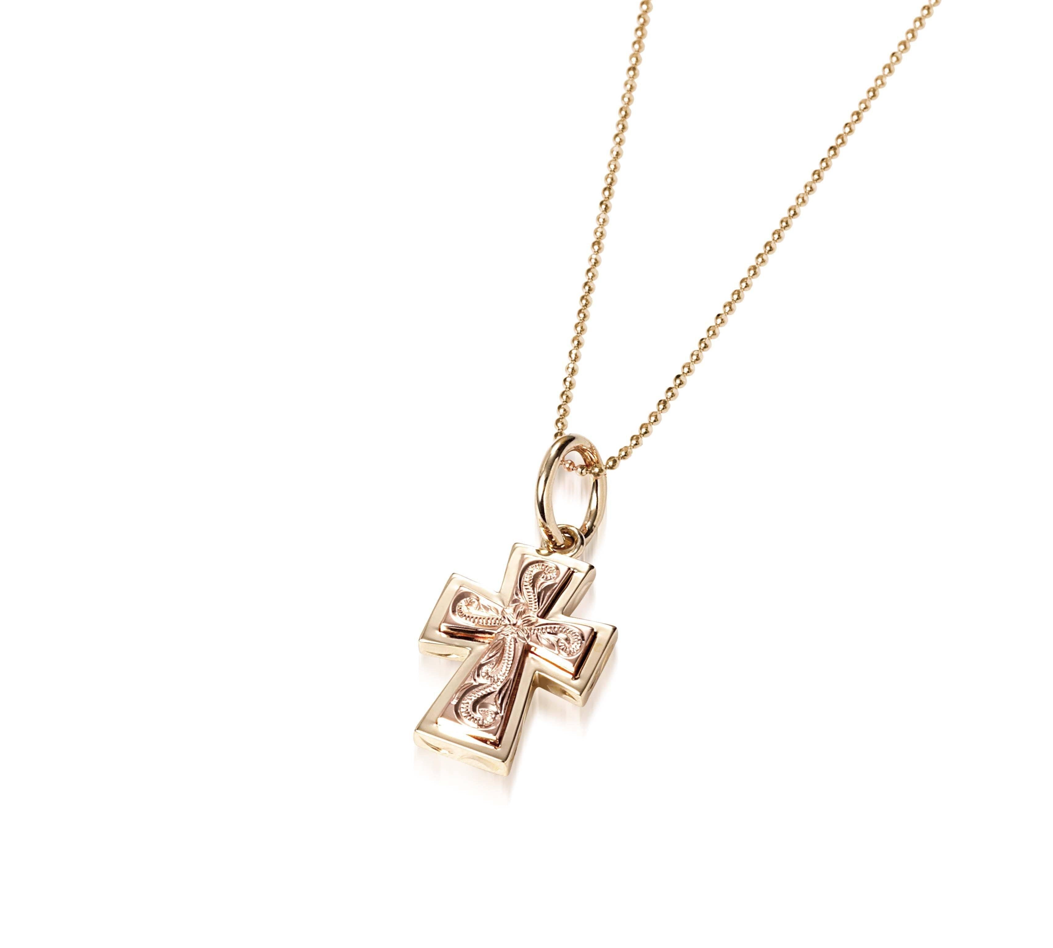 The picture shows a 14K yellow and rose gold two-tone cross pendant with hand engravings.