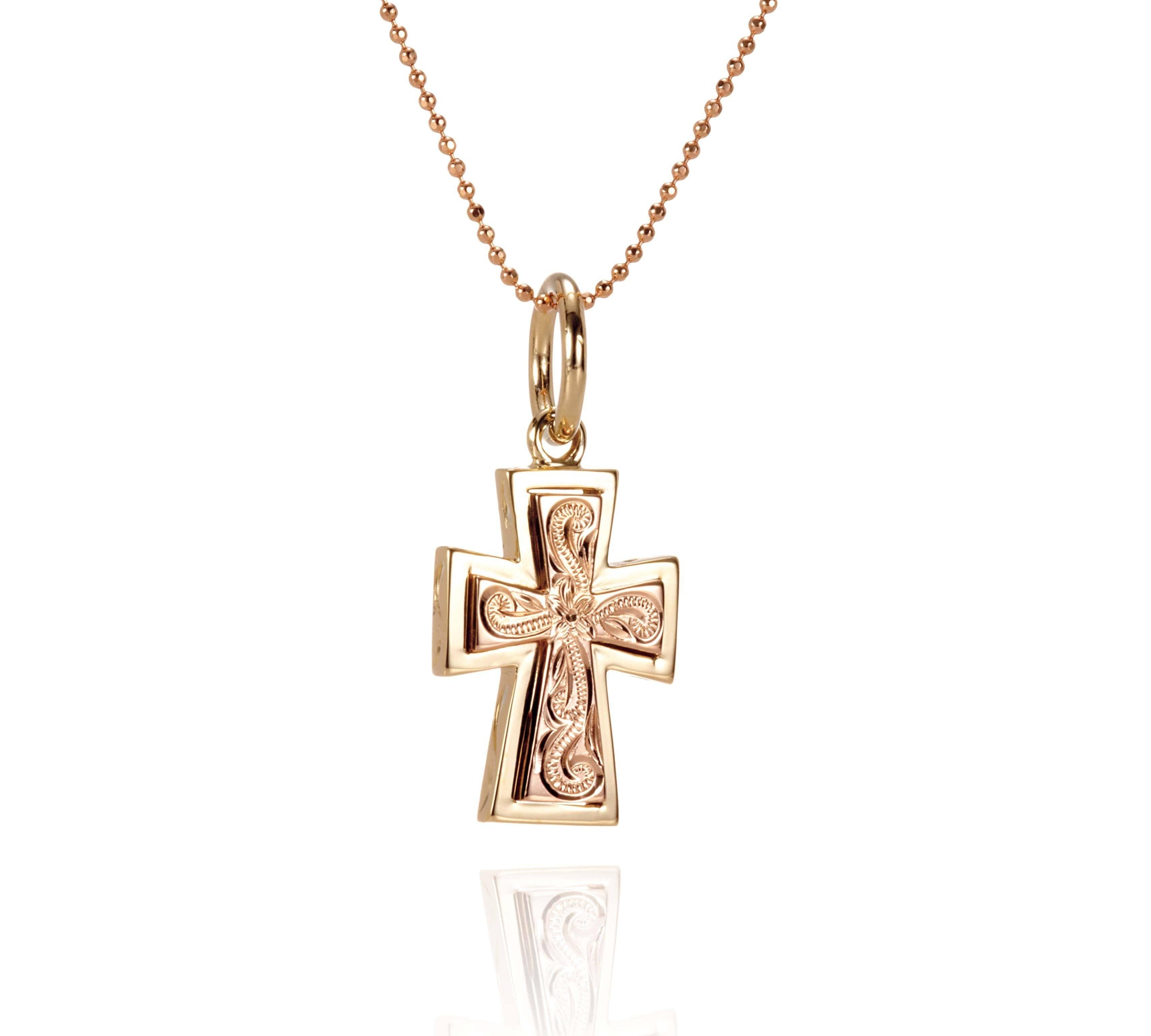 The picture shows a 14K yellow and rose gold two-tone cross pendant with hand engravings.