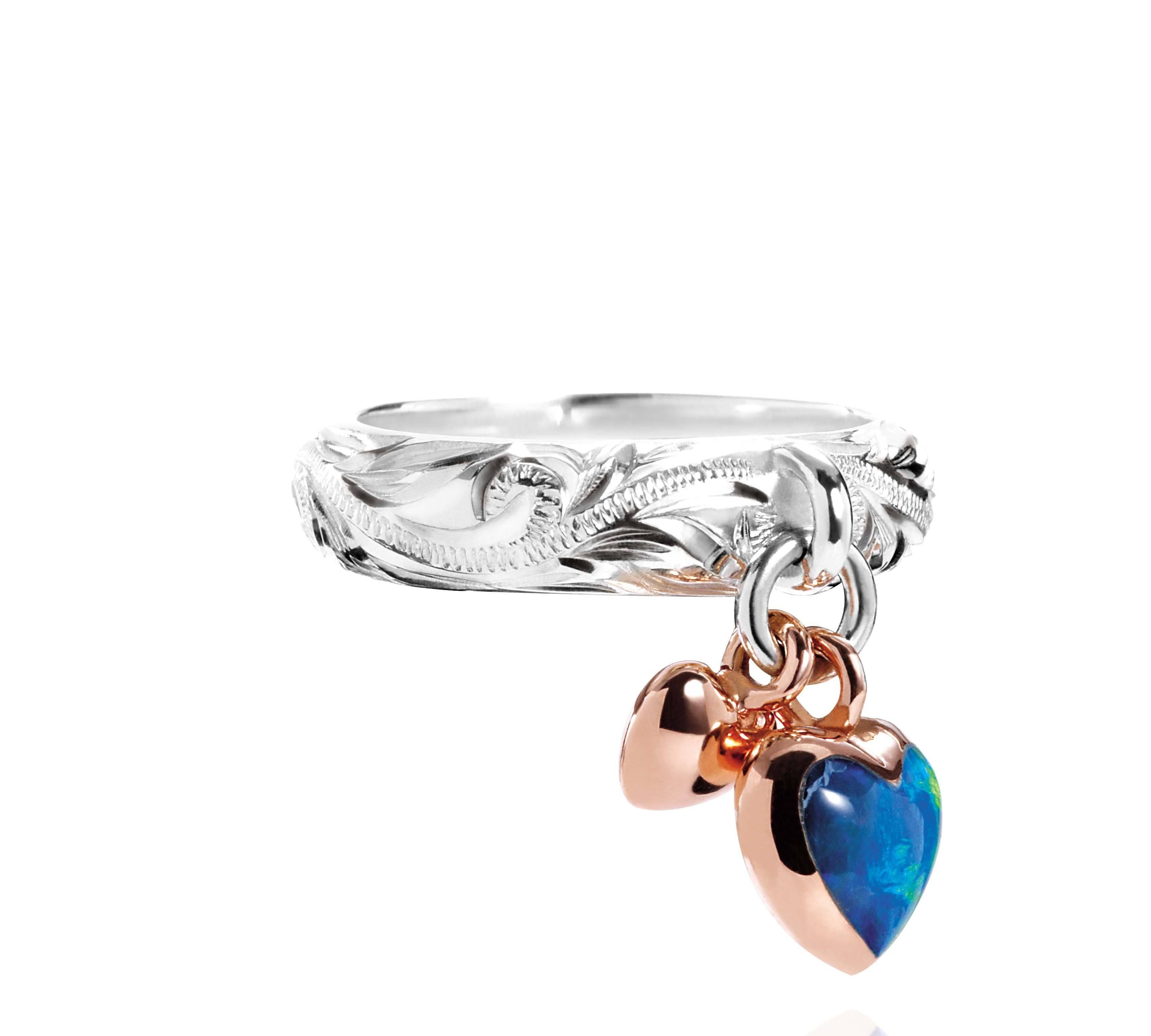 The picture shows a 14K rose gold and 925 sterling silver two-tone heart ring with hand engravings and opal.