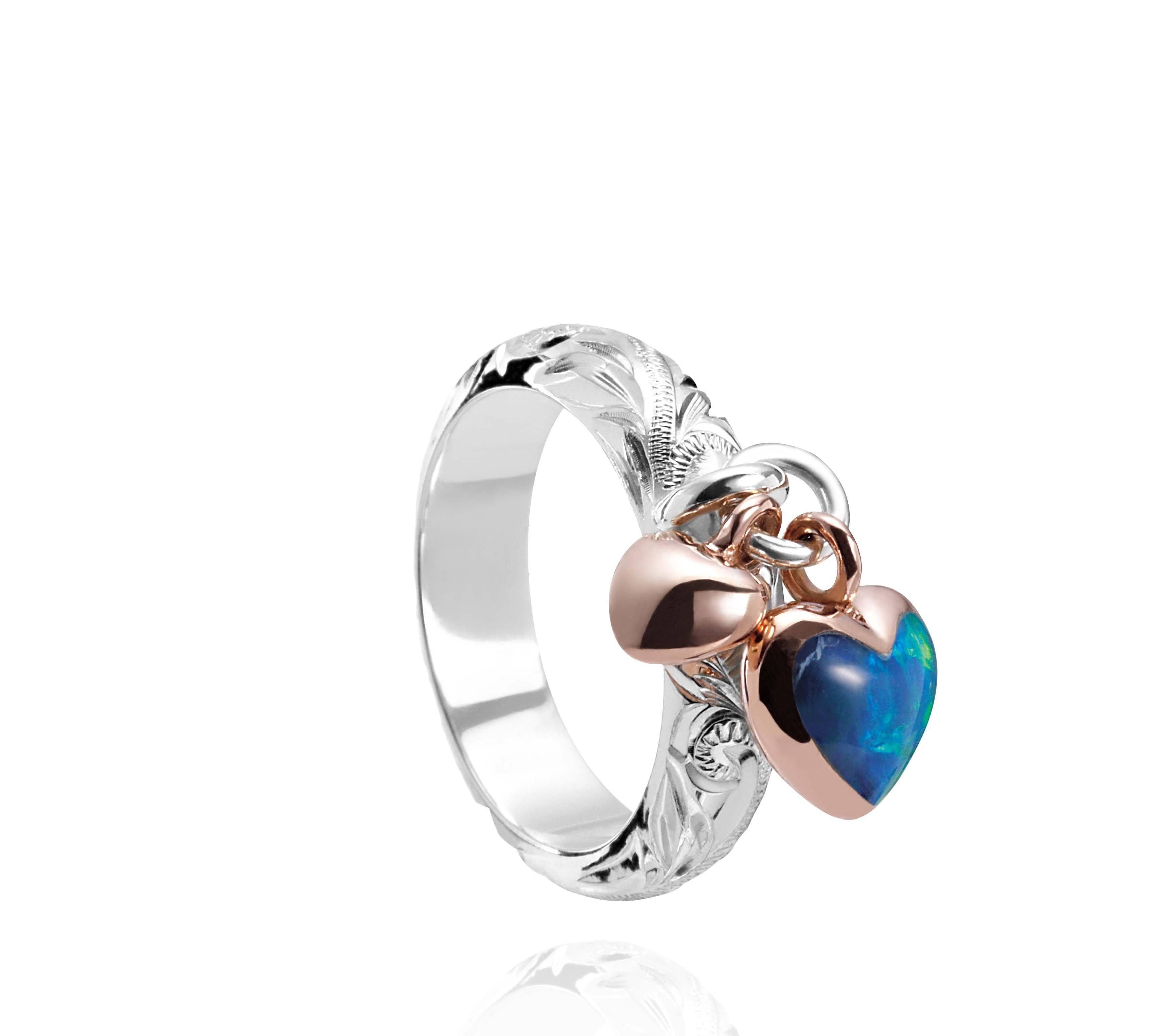 The picture shows a 14K rose gold and 925 sterling silver two-tone heart ring with hand engravings and opal.