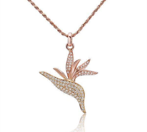 In this photo there is a rose and yellow gold two-tone bird of paradise pendant with diamonds.