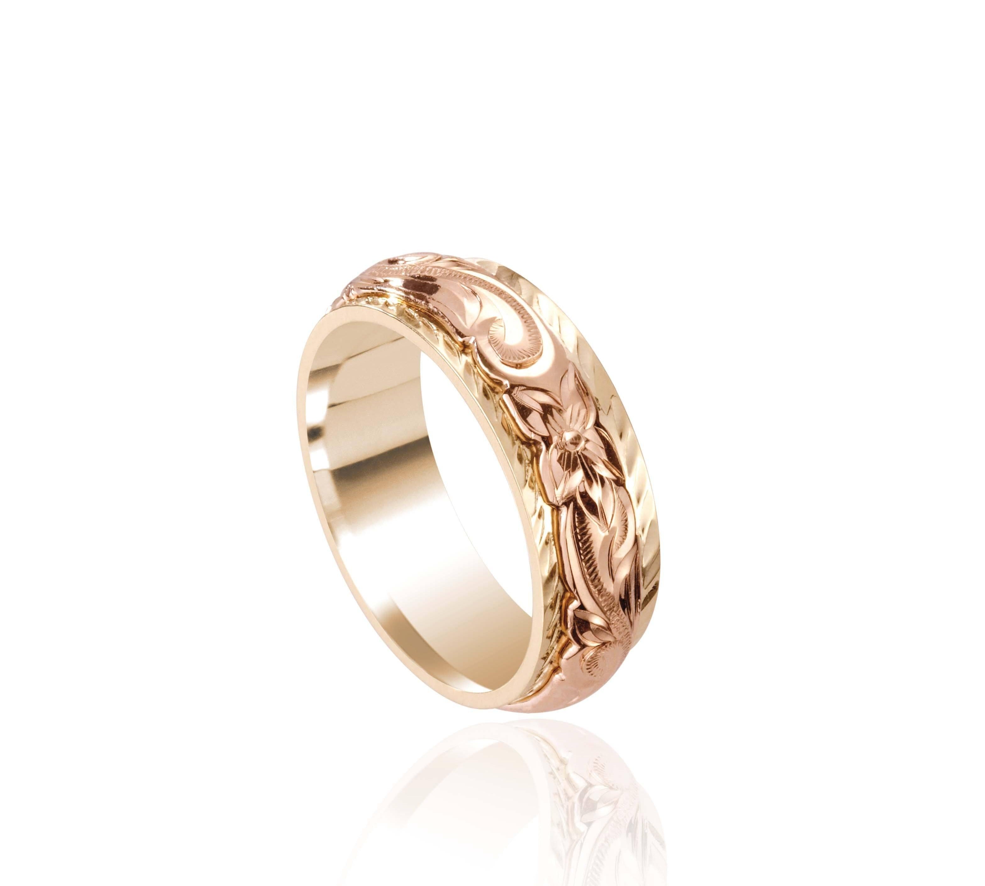 In this photo there is a rose and yellow gold two-tone ring with flower and scroll hand engravings.