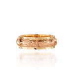 In this photo there is a rose and yellow gold two-tone ring with flower and scroll hand engravings.