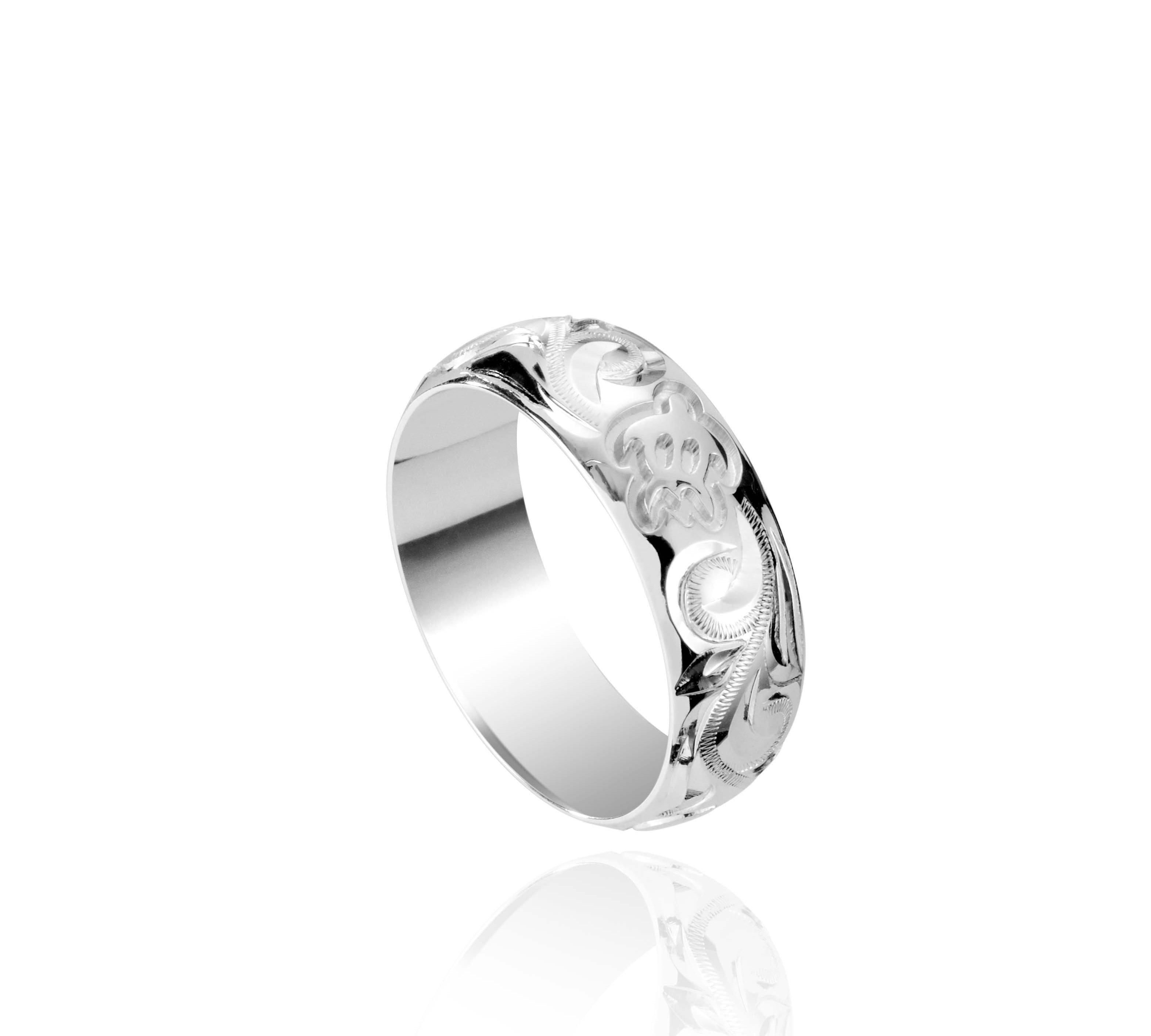 The picture shows a 18K white gold ring 6mm with hand-engravings including a sea turtle.