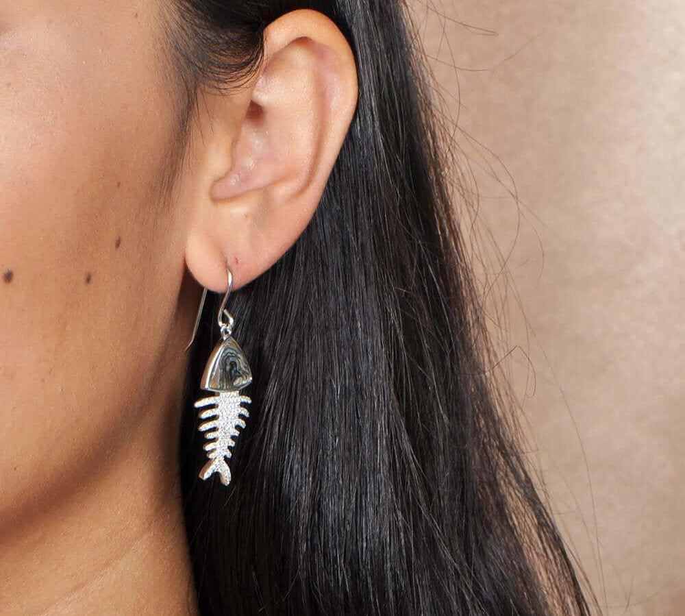 Sterling silver Fishbone hook earrings featuring abalone, and white topaz. worn by a model 