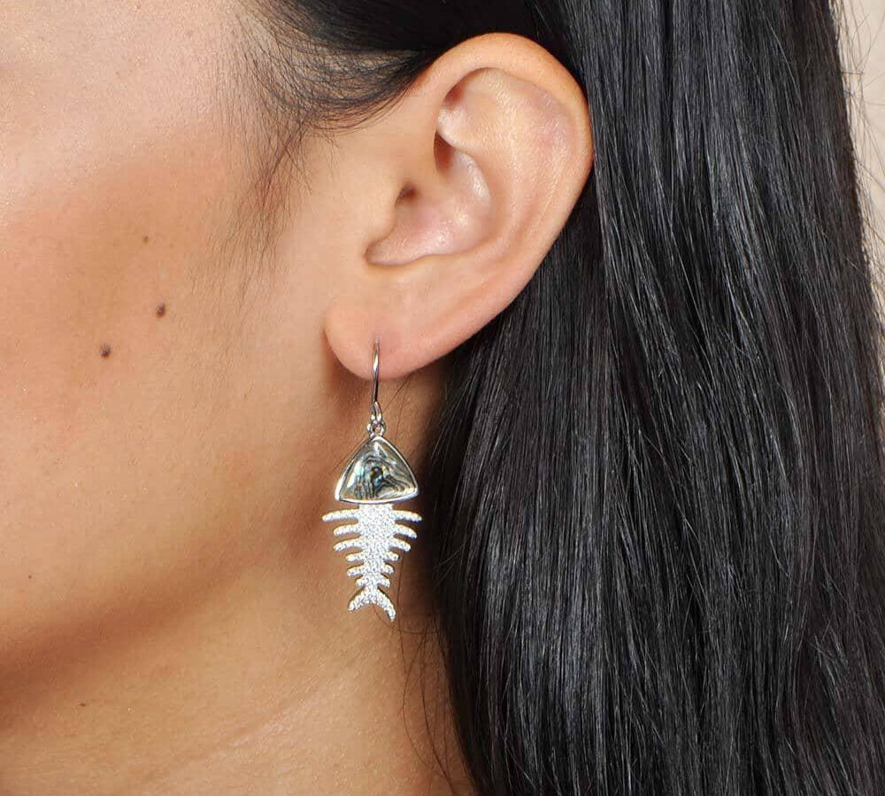A model wearing Sterling silver Fishbone hook earrings featuring abalone, and white topaz. 