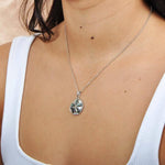 Sterling silver sand dollar pendant with abalone, worn by a model. 
