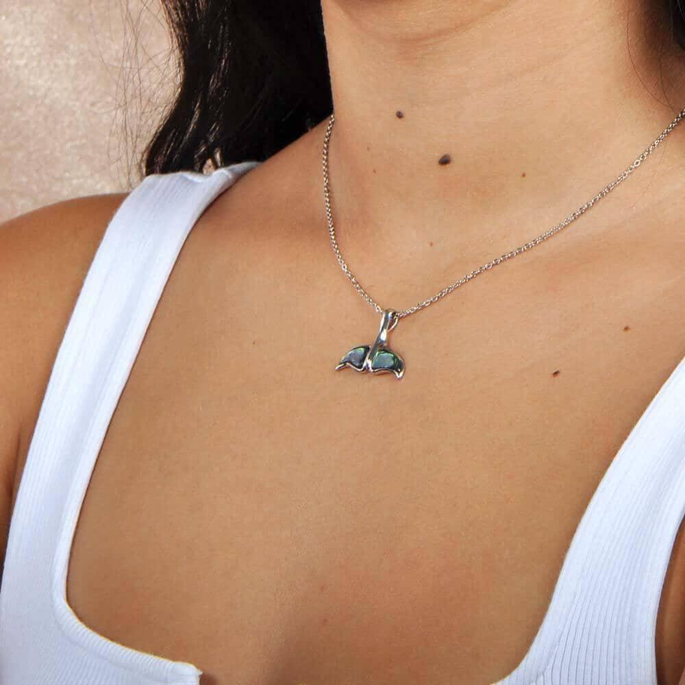 A model wearing a Sterling silver whale tail pendant featuring abalone. 