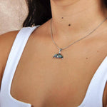 A model wearing a Sterling silver whale tail pendant featuring abalone. 