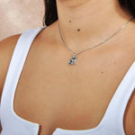 A model wearing a Stelling sliver and abalone pendant designed as a dolphin over circle. 