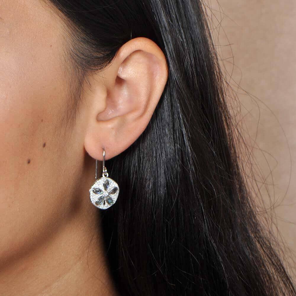 Abalone, Sterling silver, and pave sand dollar earrings worn by a model. 