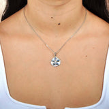 Sterling silver sand dollar pendant featuring Pave and iridescent abalone worn by a model