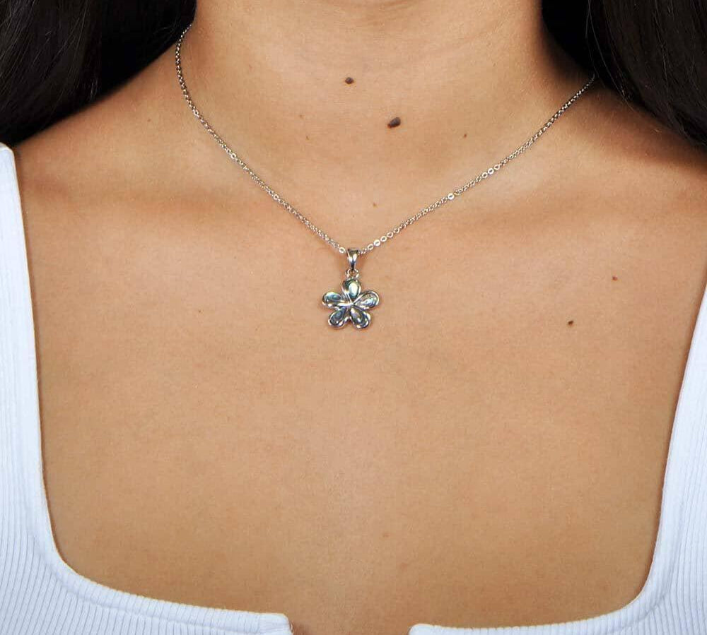 Abalone and sterling silver plumeria shaped pendant, worn by a model.