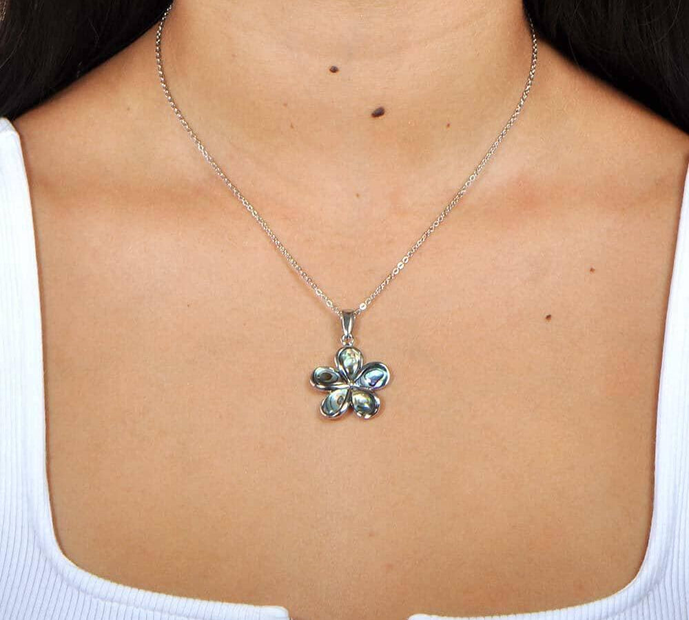 A model wearing a Sterling silver plumeria pendant featuring Abalone pedals.