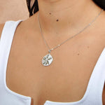 Sterling silver and Abalone Sand dollar pendant. The pendant is worn by a model. 