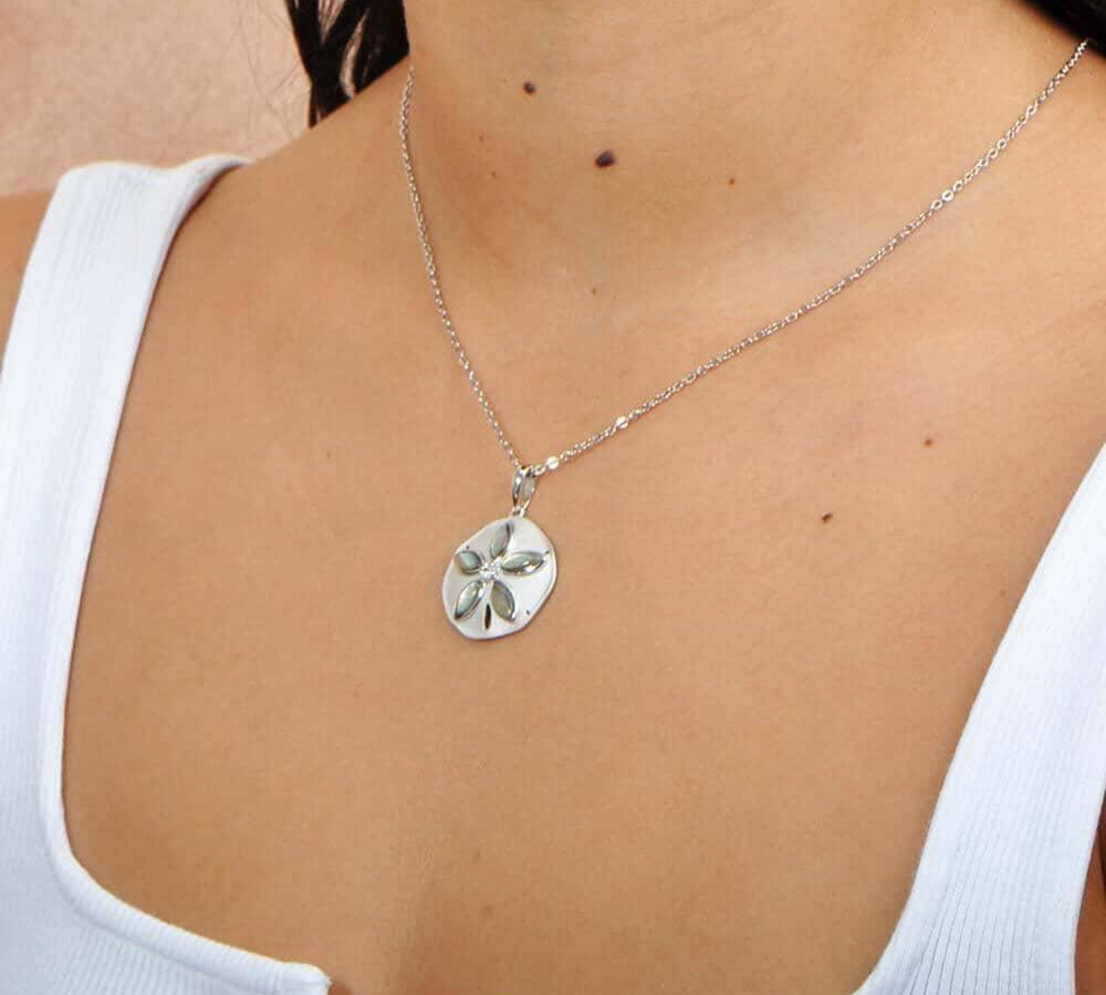 Sterling silver and Abalone Sand dollar pendant. The pendant is worn by a model. 
