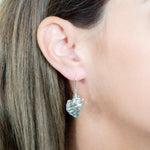The picture shows a model wearing a 925 sterling silver conch shell hook earring.