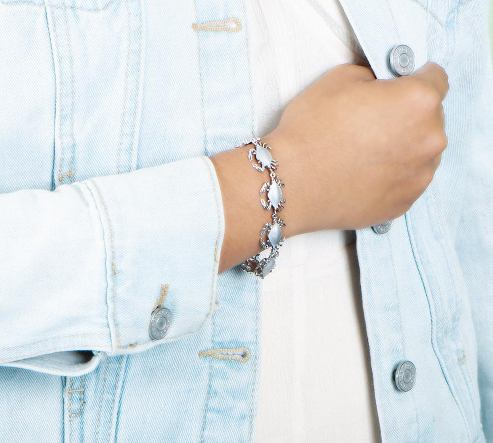 The picture shows a model wearing a  925 sterling silver white gold-plated blue crab bracelet.