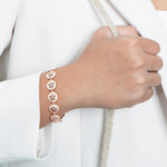 The picture shows a model wearing a 925 sterling silver rose gold-plated sand dollar bracelet with topaz