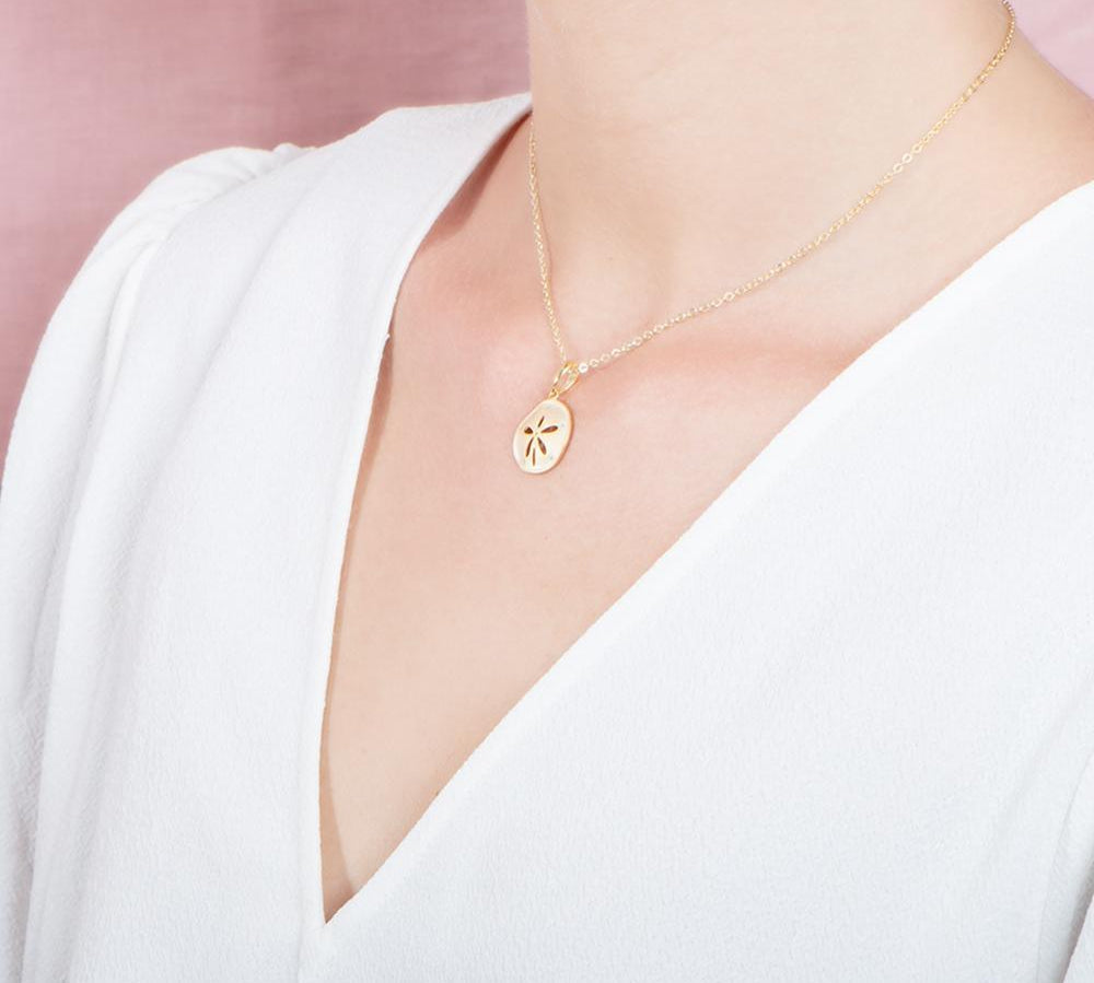 The picture shows a 925 sterling silver, yellow gold plated, sand dollar pendant with topaz.