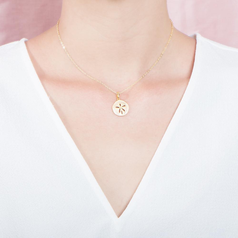 The picture shows a 925 sterling silver, yellow gold plated, sand dollar pendant with topaz.