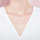 The picture shows a 925 sterling silver, yellow gold plated, sand dollar pendant with topaz.