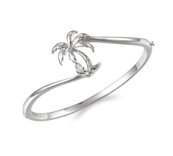 In this photo there is a 925 sterling silver beachside palm tree bangle with a topaz gemstone.