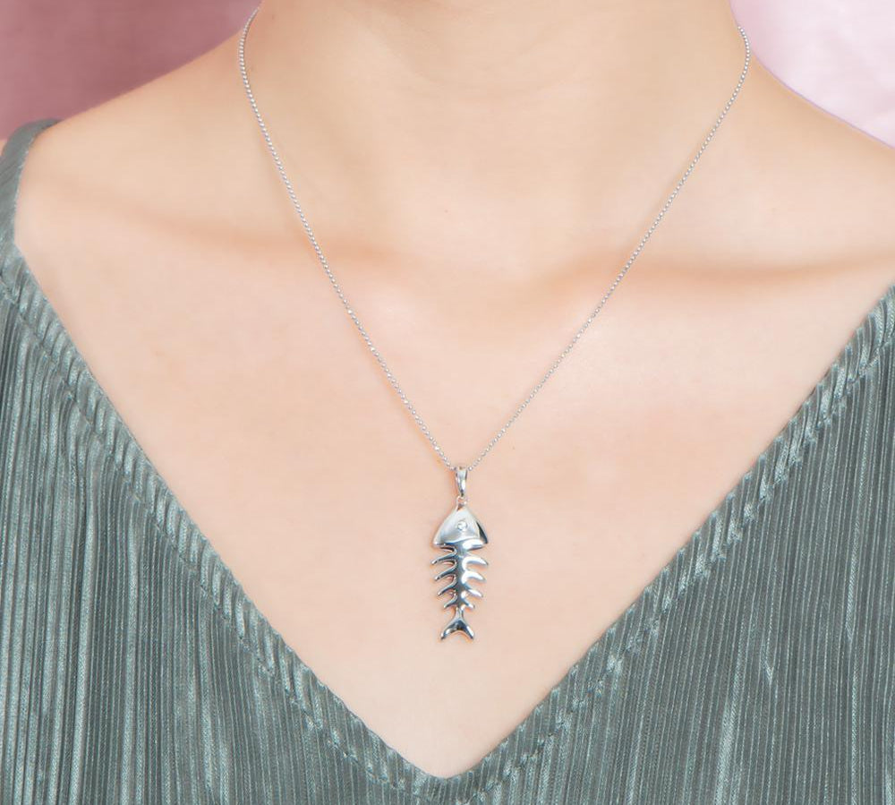 The picture shows a 925 sterling silver fishbone pendant with topaz.