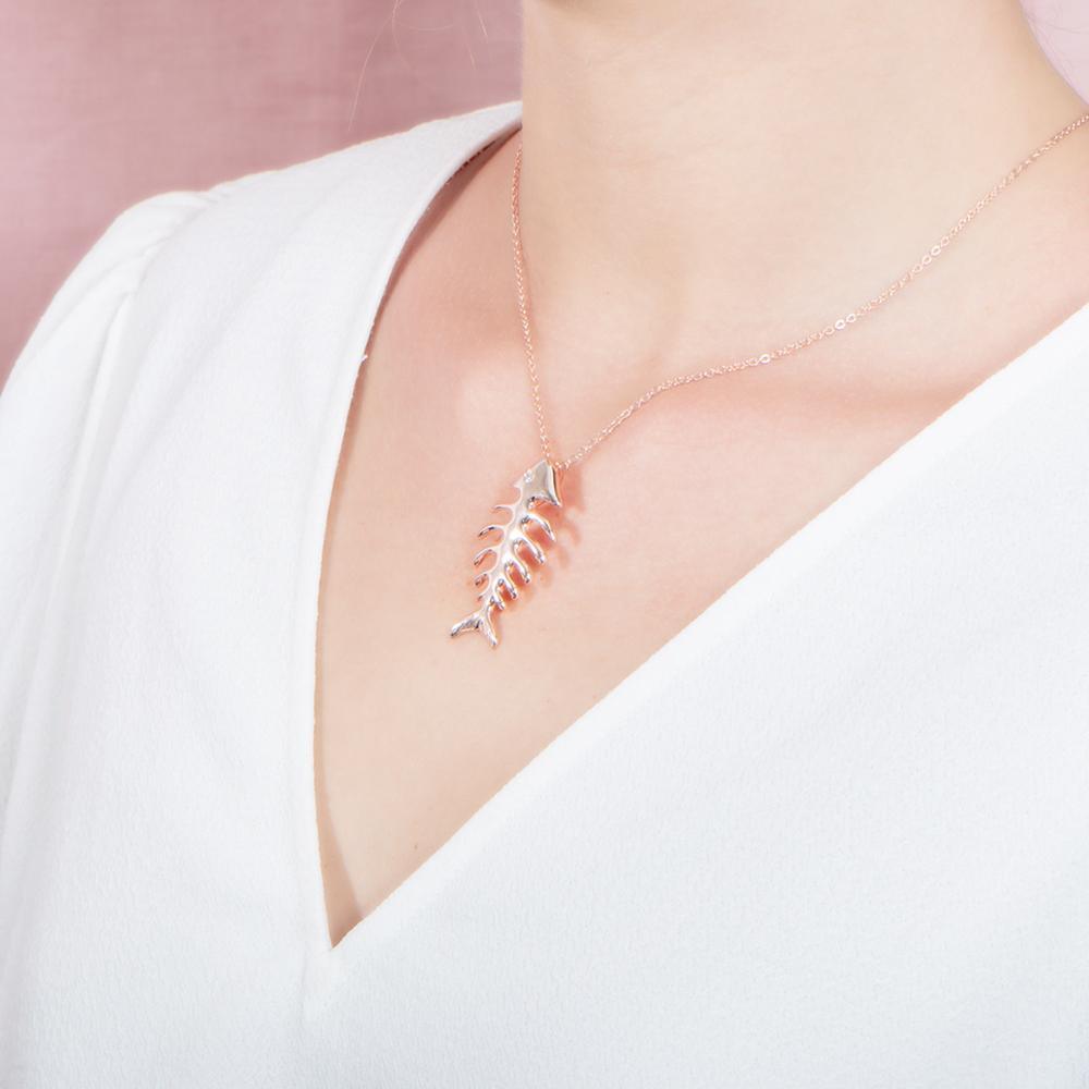 The picture shows a 925 sterling silver white gold vermeil fish bone pendant paired with cubic zirconia.