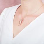 The picture shows a 925 sterling silver white gold vermeil fish bone pendant paired with cubic zirconia.