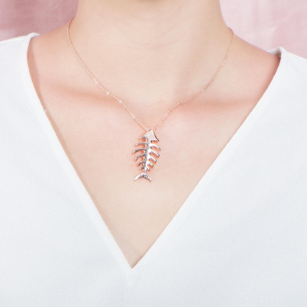 The picture shows a 925 sterling silver rose gold vermeil fish bone pendant paired with cubic zirconia.