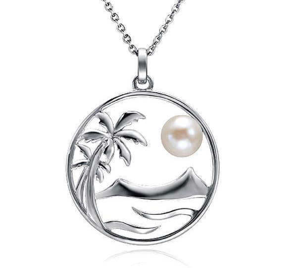 In this photo there is a white gold pendant with two palm trees, Diamond Head, and ocean waves placed within a circle, with one white pearl.