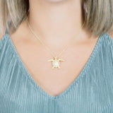 The picture shows a 925 sterling silver, yellow gold plated, sea turtle pendant with topaz.
