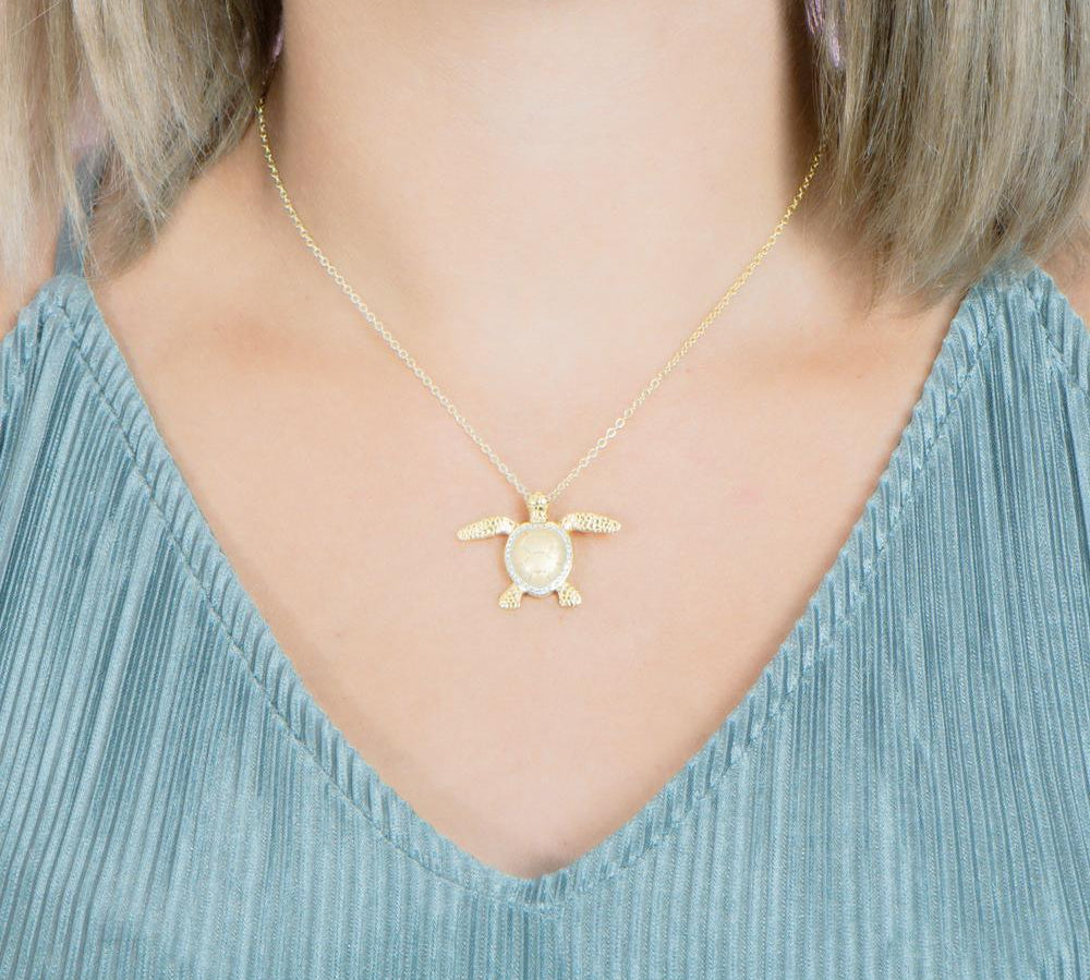 The picture shows a 925 sterling silver, yellow gold plated, sea turtle pendant with topaz.