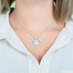 The picture shows a 925 sterling silver, white gold plated, sea turtle pendant with topaz.