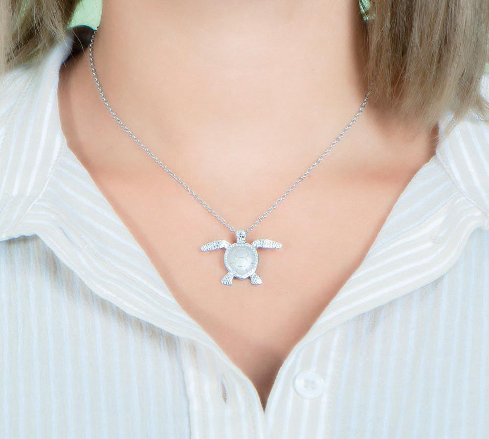The picture shows a 925 sterling silver, white gold plated, sea turtle pendant with topaz.