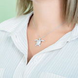 The picture shows a 925 sterling silver, white gold plated, sea turtle pendant with topaz.