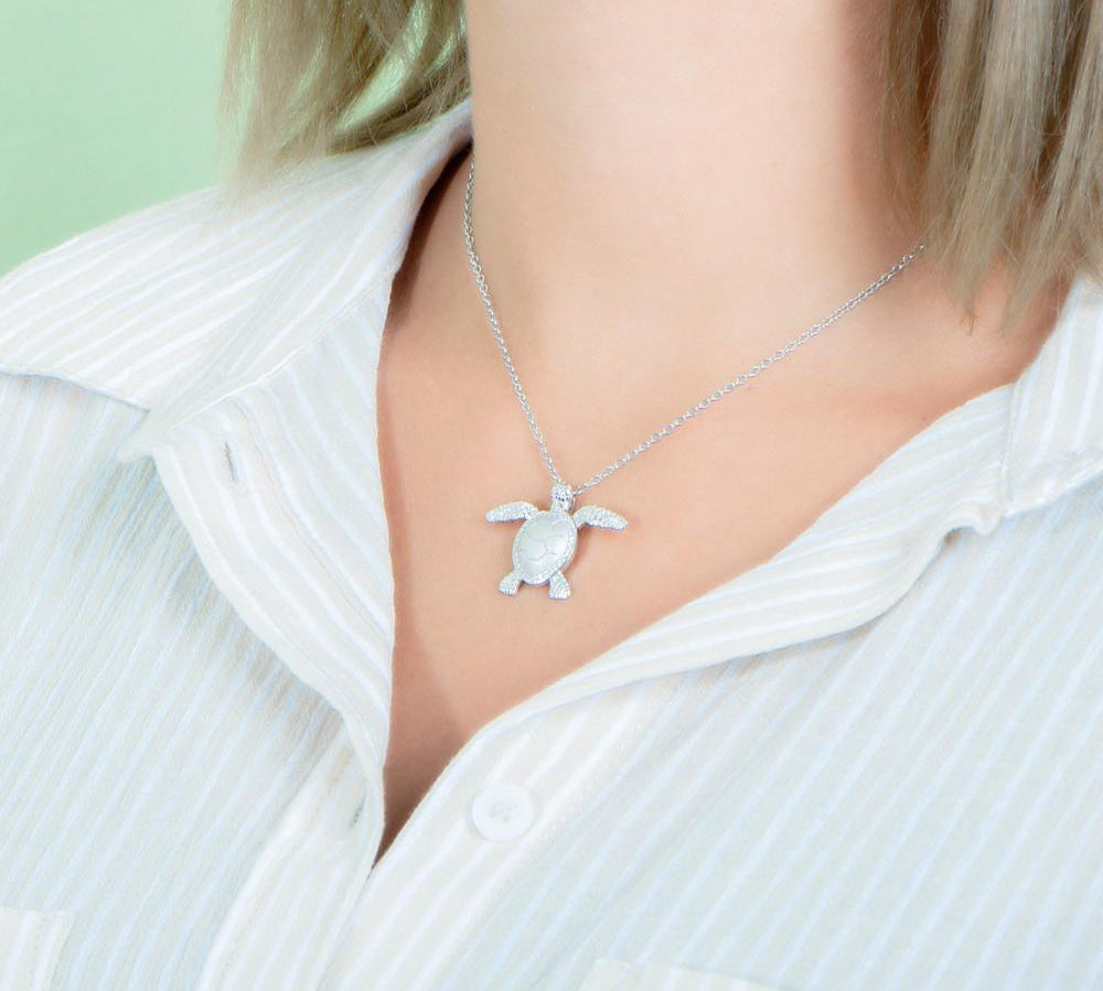 The picture shows a 925 sterling silver, white gold plated, sea turtle pendant with topaz.
