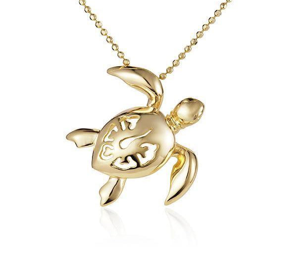 In this photo there is a yellow gold sea turtle necklace with a hibiscus flower cut-out.